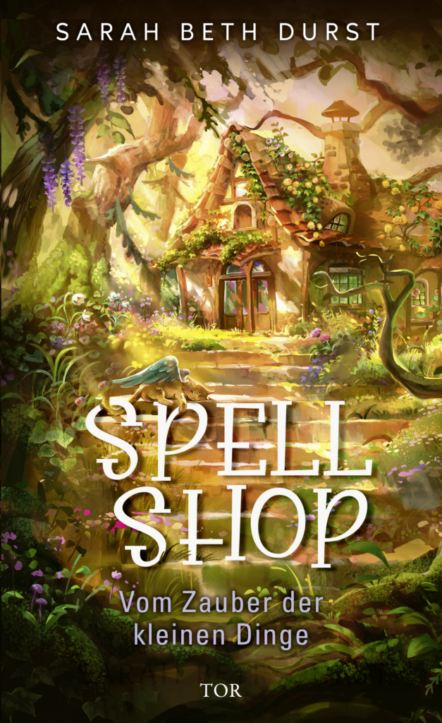 Oben steht „Sarah Beth Durst". Unten steht „Spellshop, Vom Zauber der kleinen Dinge". Ein Cover, welches ein Haus in mitten eines Waldes steht. Viele Bäume, Pflanzen, Gras aber auch eine Steintreppe die zum Haus führt.